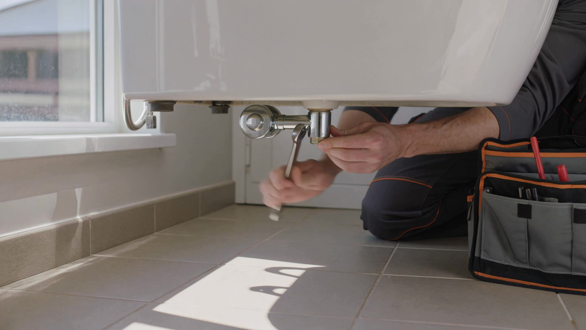 Plombier au travail dans une salle de bain rénovée