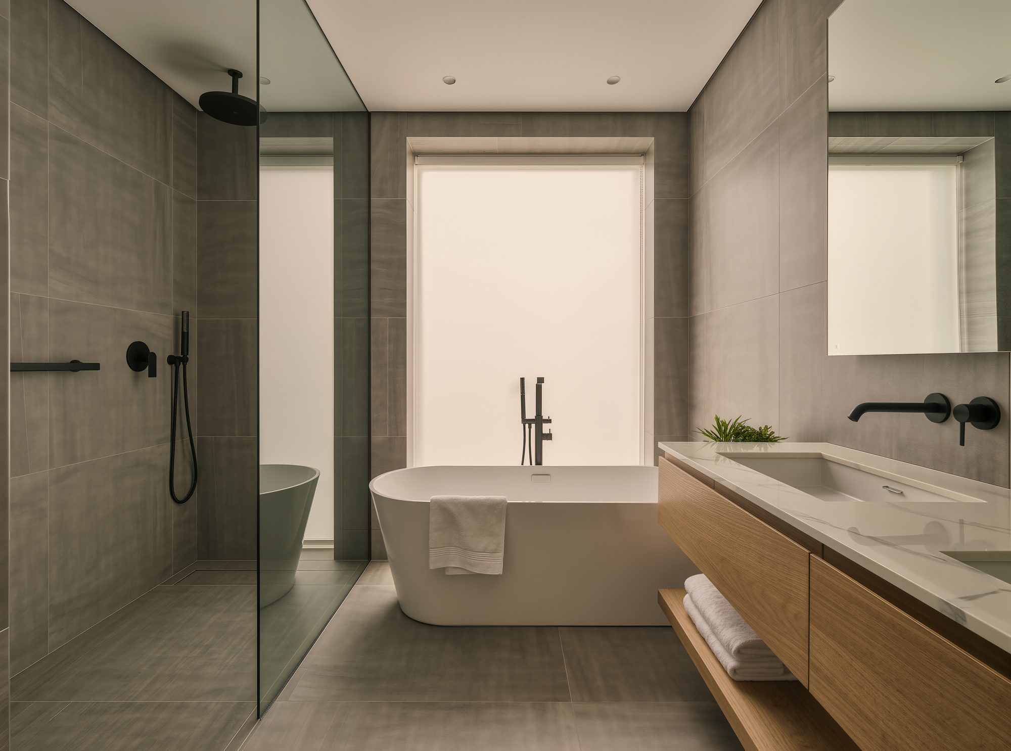 Salle de bain rénovée avec douche vitrée, vanité en bois et robinetterie noire mate